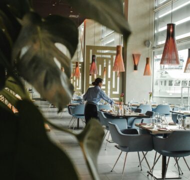 woman in front on brown dining table and chairs inside building